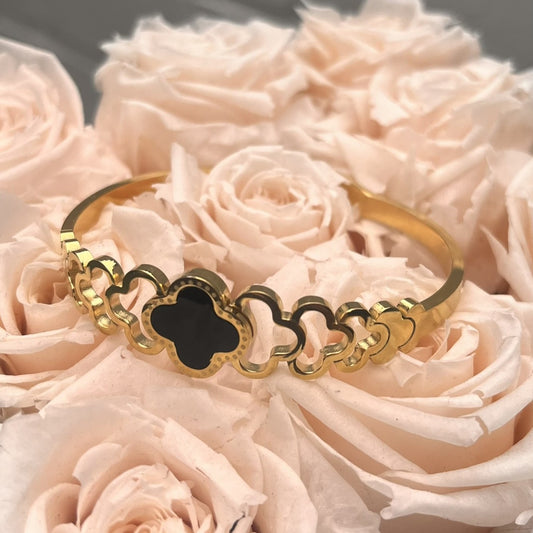Goldfarbener Edelstahl Armreif mit schwarzem Kleeblatt-Design