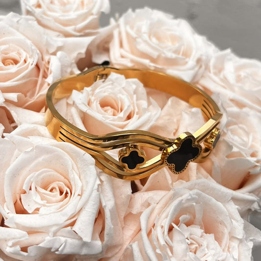 Goldfarbener Edelstahl Armreif mit 3 schwarzen Kleeblättern