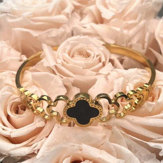 Goldfarbener Edelstahl Armreif mit schwarzem Kleeblatt-Design